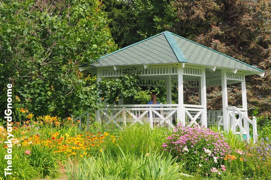 A beautiful white gazebo in a blooming garden