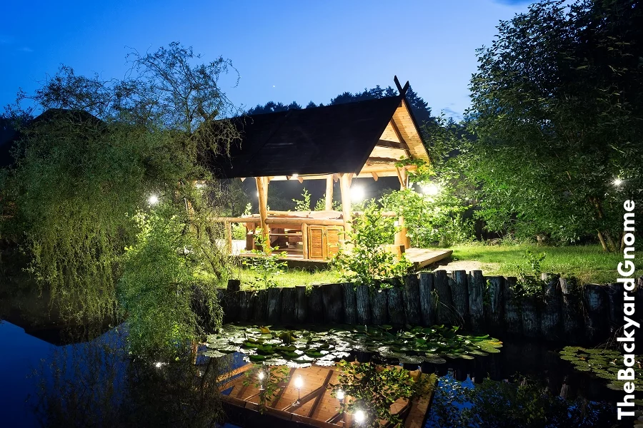 Wooden gazebo lit lanterns on the lake